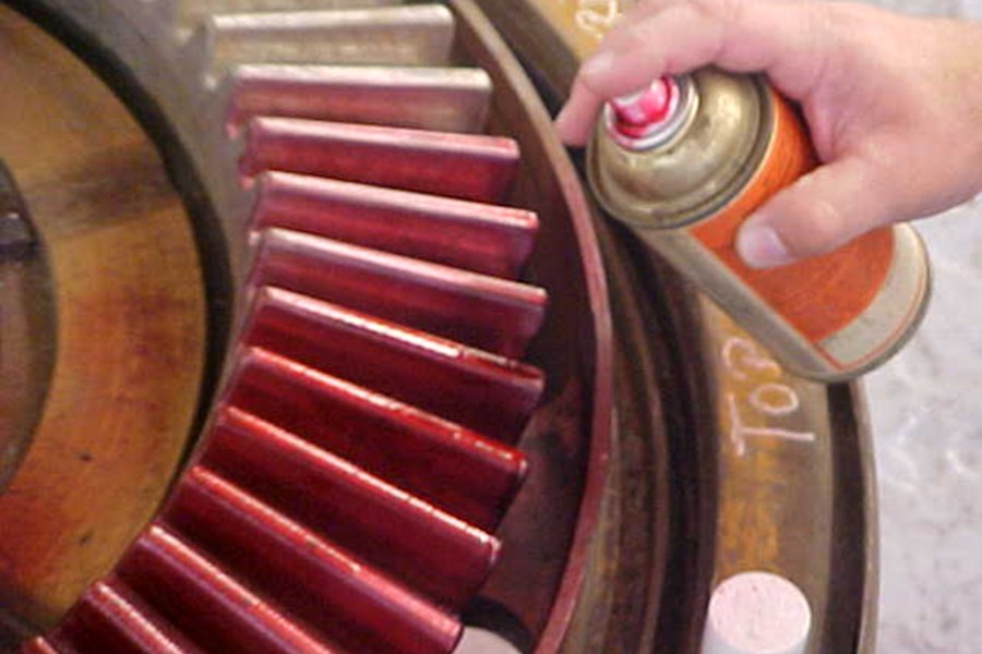 Contact pattern check being sprayed onto gear teeth during inspection