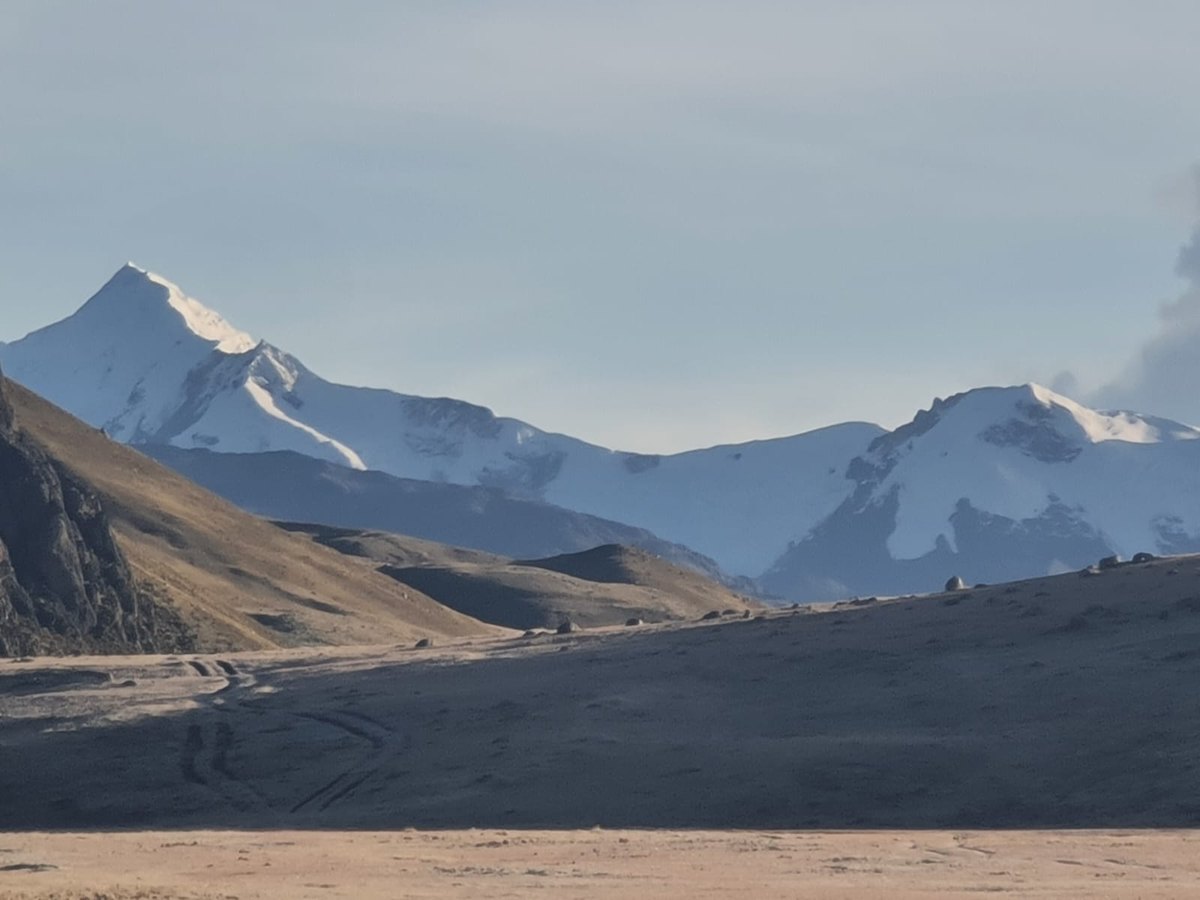 Snow-capped peaks above a high-altitude mining road